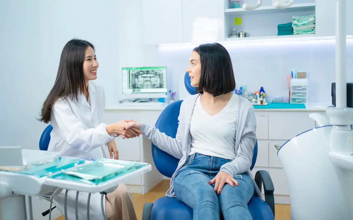 Caucasian girl patient greeting dentist by making handshake in c