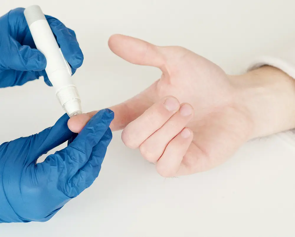 measuring-blood-sugar-hand-blue-gloves