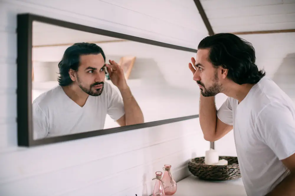 A,Handsome,Man,Looks,In,The,Mirror.,Men’s,Personal,Care.