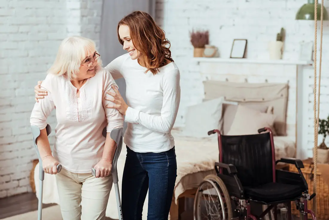 Pleasant caring woman helping with rehabilitation her disabled grandmother