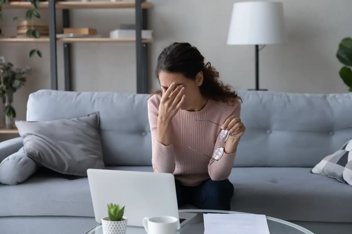 Exhausted woman taking off glasses, suffering from eye strain