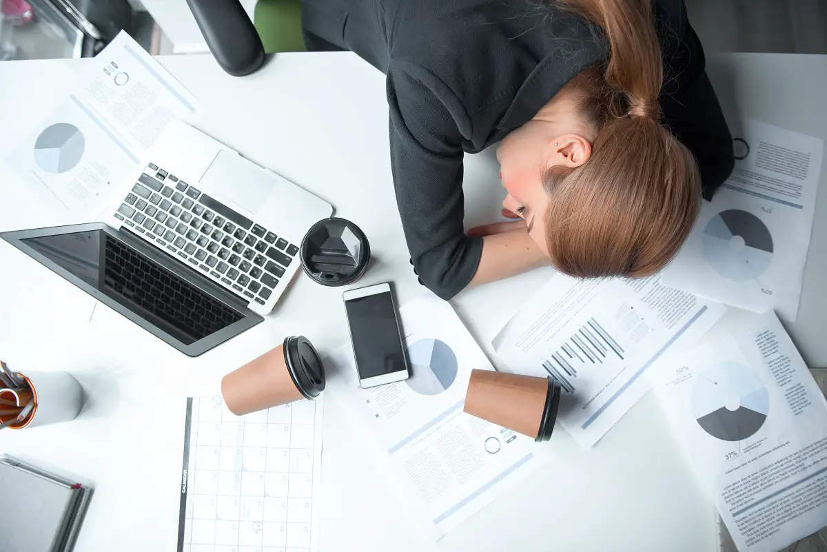 Serious tired businesswoman sleeping on table